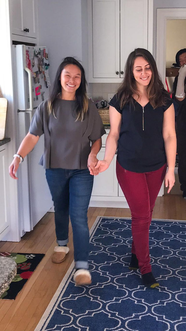 Kate and Sylvia practicing their entrance for their wedding dance in the kitchen, preparing for their big day.