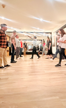 ReKindle Dance instructor Matthew teaching leaders and followers their parts in a partner dance at Studio Uplift.
