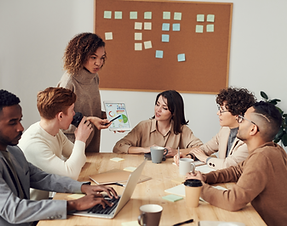 A presenter showing mental health data and charts on a tablet to a diverse group of employees during a corporate meeting.