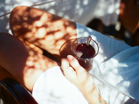 Woman drinking morning coffee outside in natural light, enjoying a mindful morning habit for sustainable New Year change