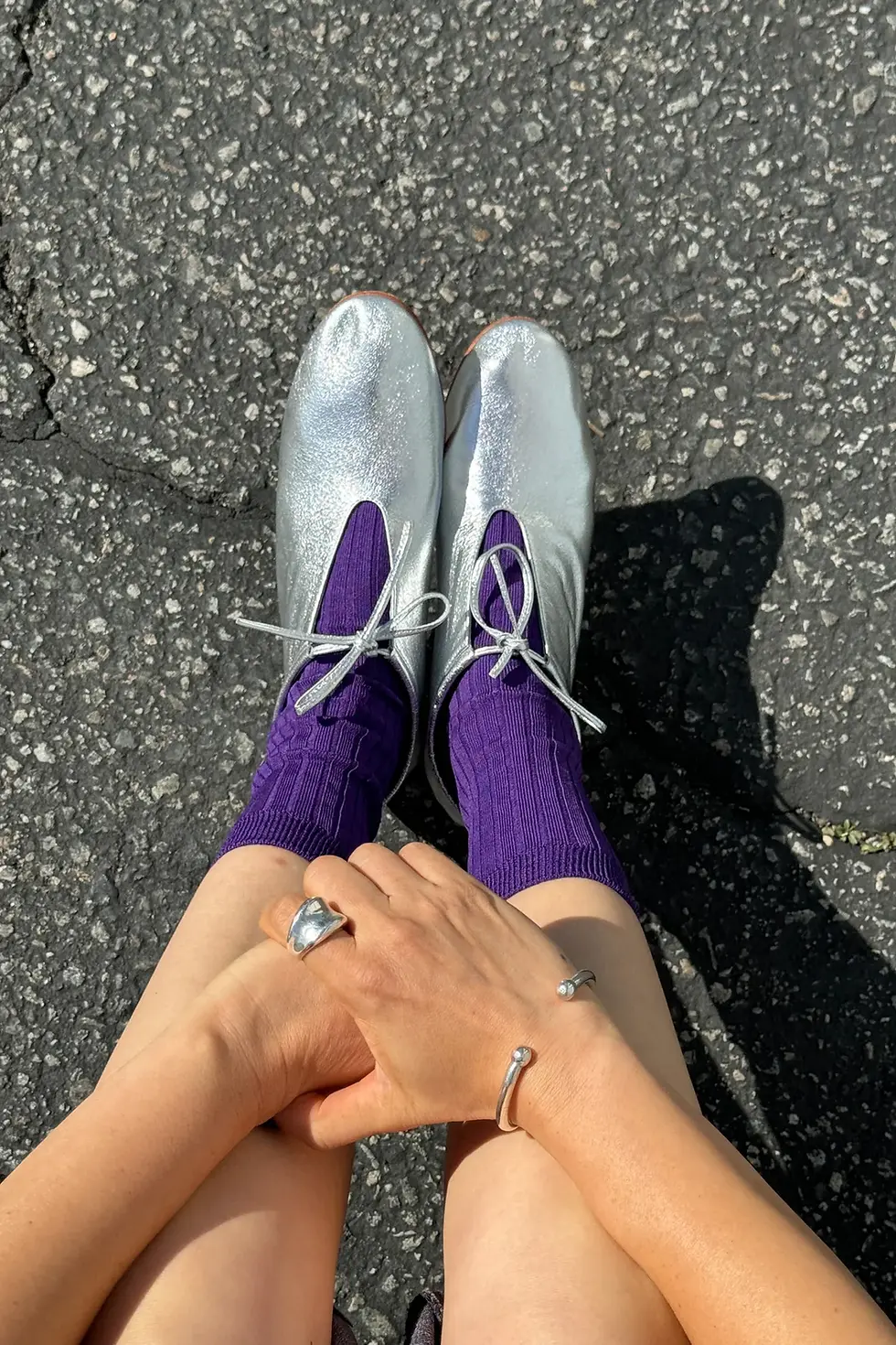 Thumbnail: a pair of silver shoes and bright purple socks from le bon shoppe