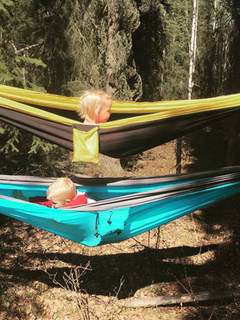 Two kids in nature school sleeping in hammocks
