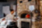 Italian Chef Putting Pizza Into a Wood Fired Oven