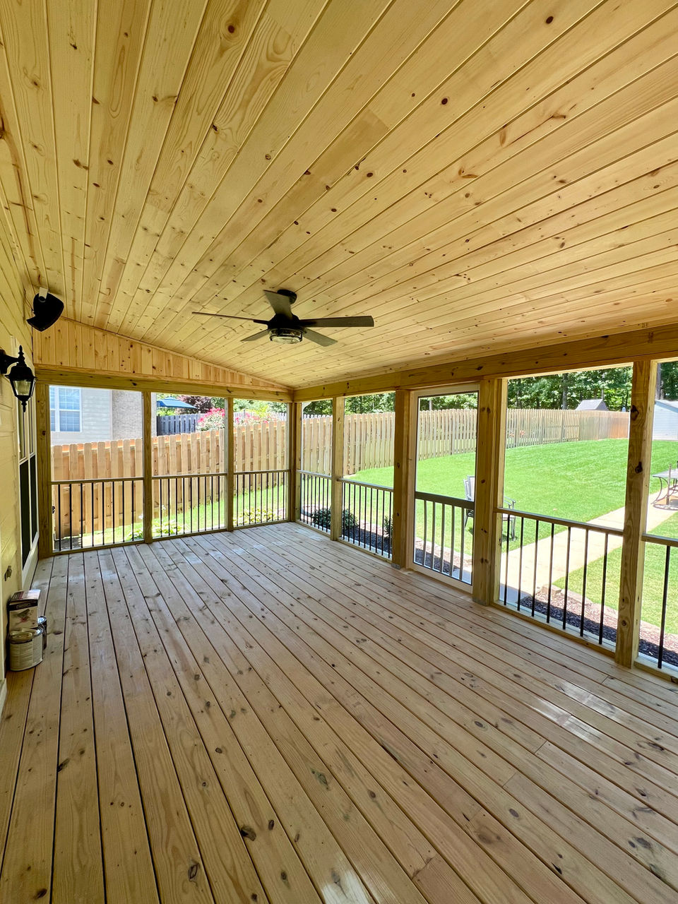 Interior view of screened porch with new pressure treated deck, tongue and groove ceiling, aluminum handrails, and ceiling fan.