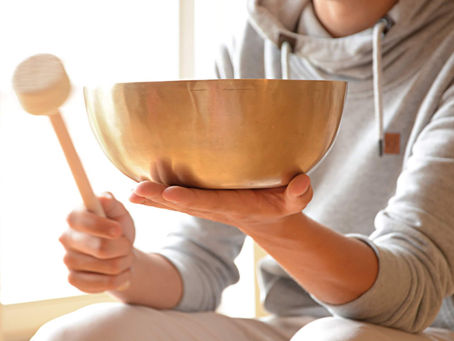 Ein Mann schlägt eine Klangschale an