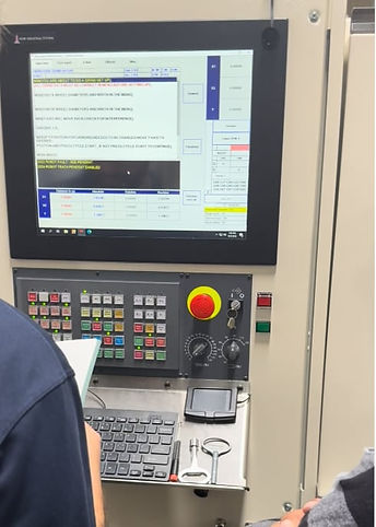 NEMT team members review machine controls and training documentation during hands-on ProGrind CNC grinder operator training.