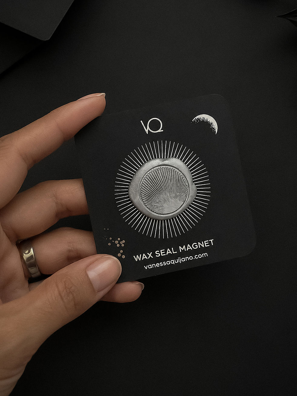 Silver wax seal magnet displayed on a black presentation card.