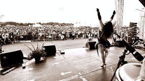 Tropicalia Brazilian singer and band on stage performing for a large crowd at Goan festival in London