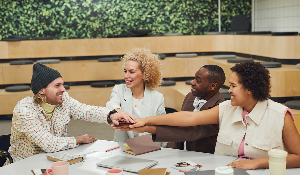 Diverse team of coworkers smiling and collaborating around a table, representing a supportive work environment enabled by Employee Assistance Programs.