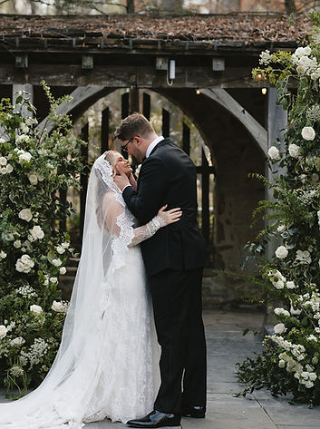 Couple kissing during wedding ceremony.