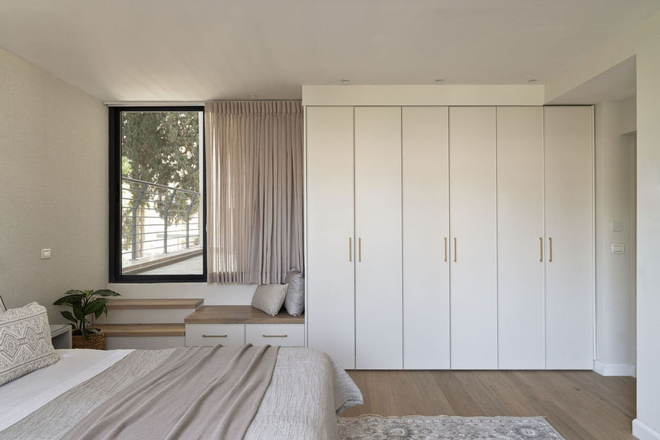 Bedroom with large closet, window, and neutral tones. Alyssa Magid Interiors