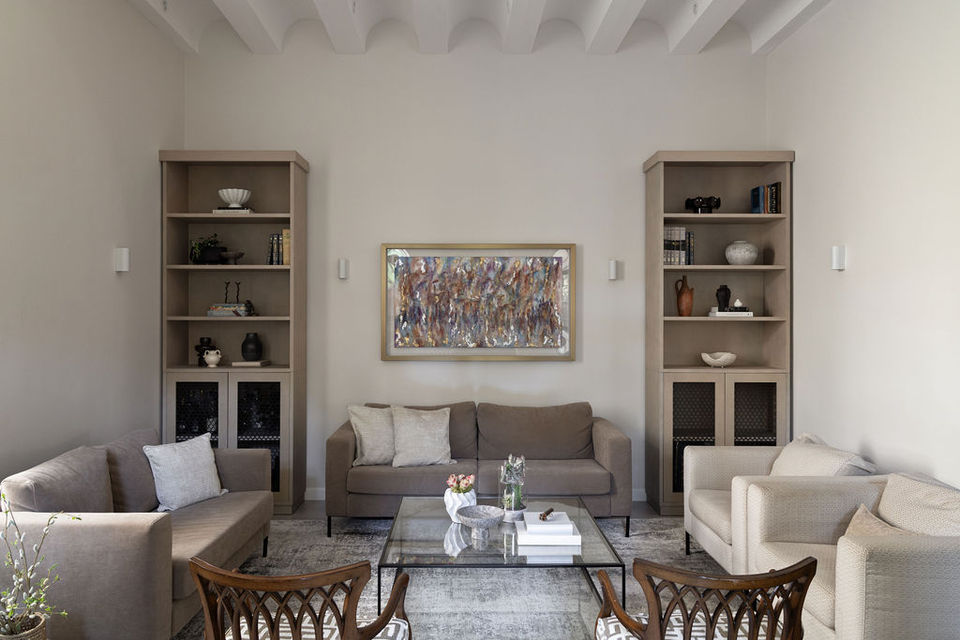 Living room interior with two sofas and bookshelves, neutral wall color.