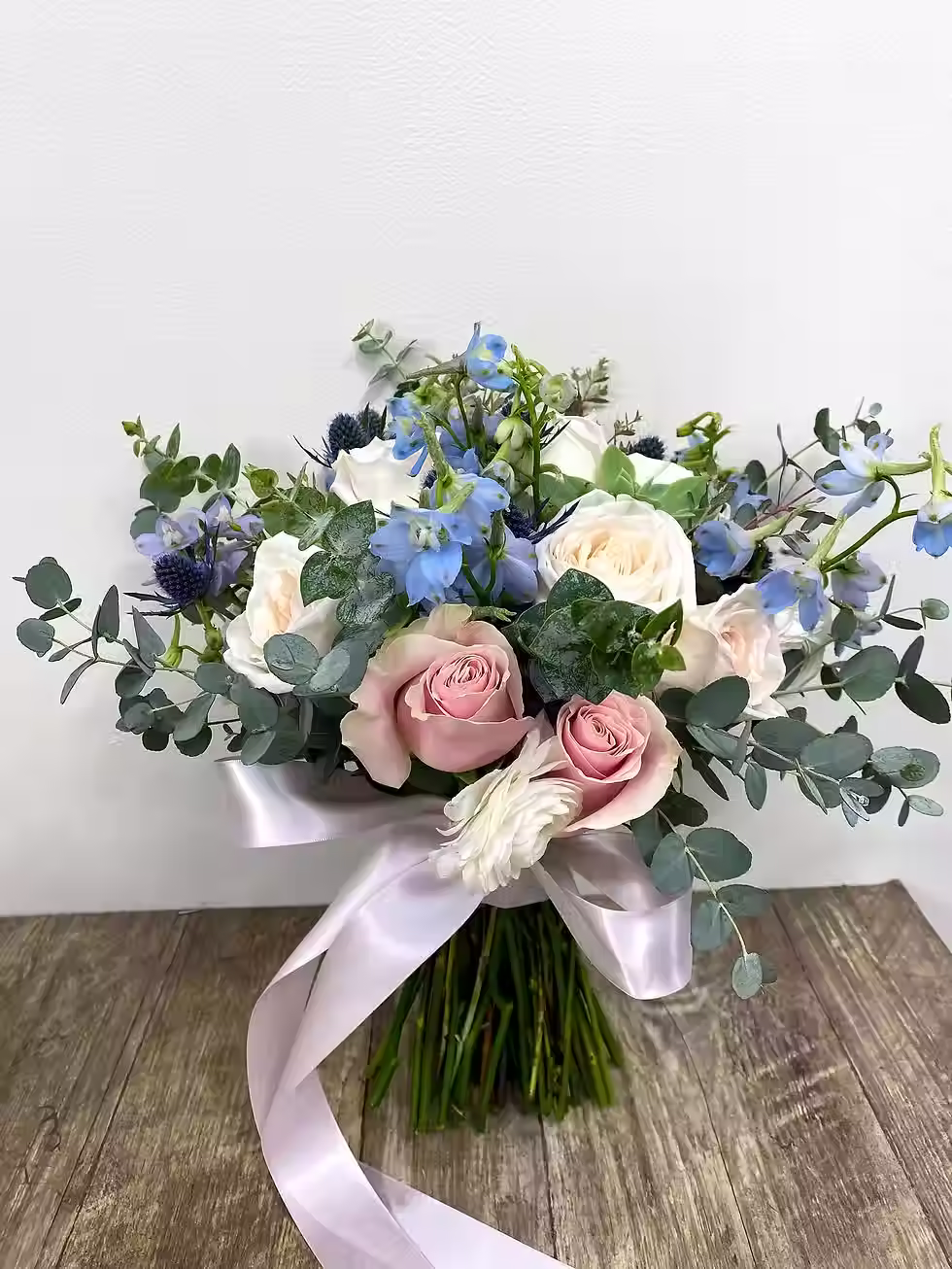 Price: $200.00
A blend of garden roses, delphinium, eryngium, roses with gunni eucalyptus