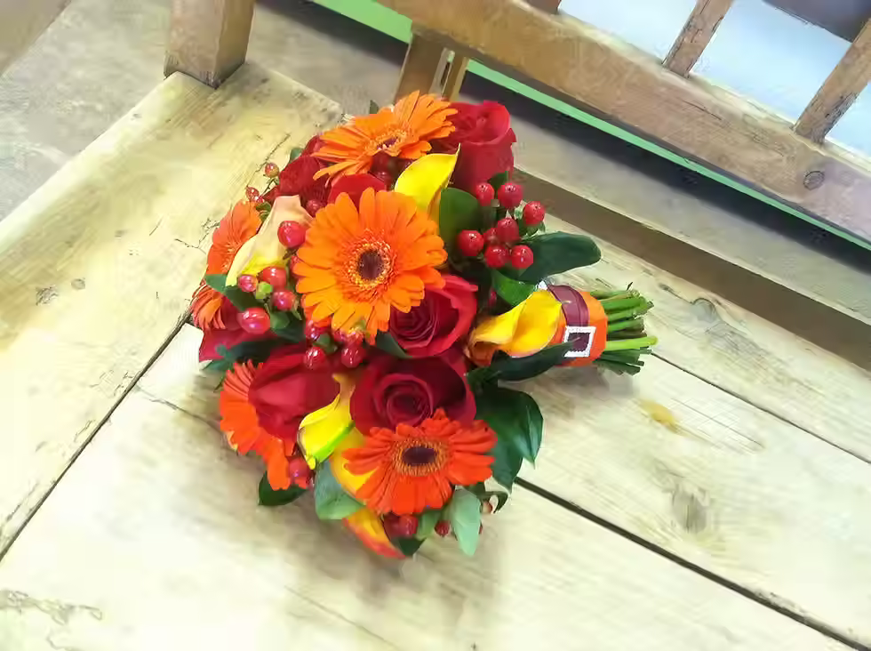 Price: $225.00
This bouquet combines gerbera daisies, roses, Flame mini calla lilies, and red coffee bean for a fun seasonal bouquet.