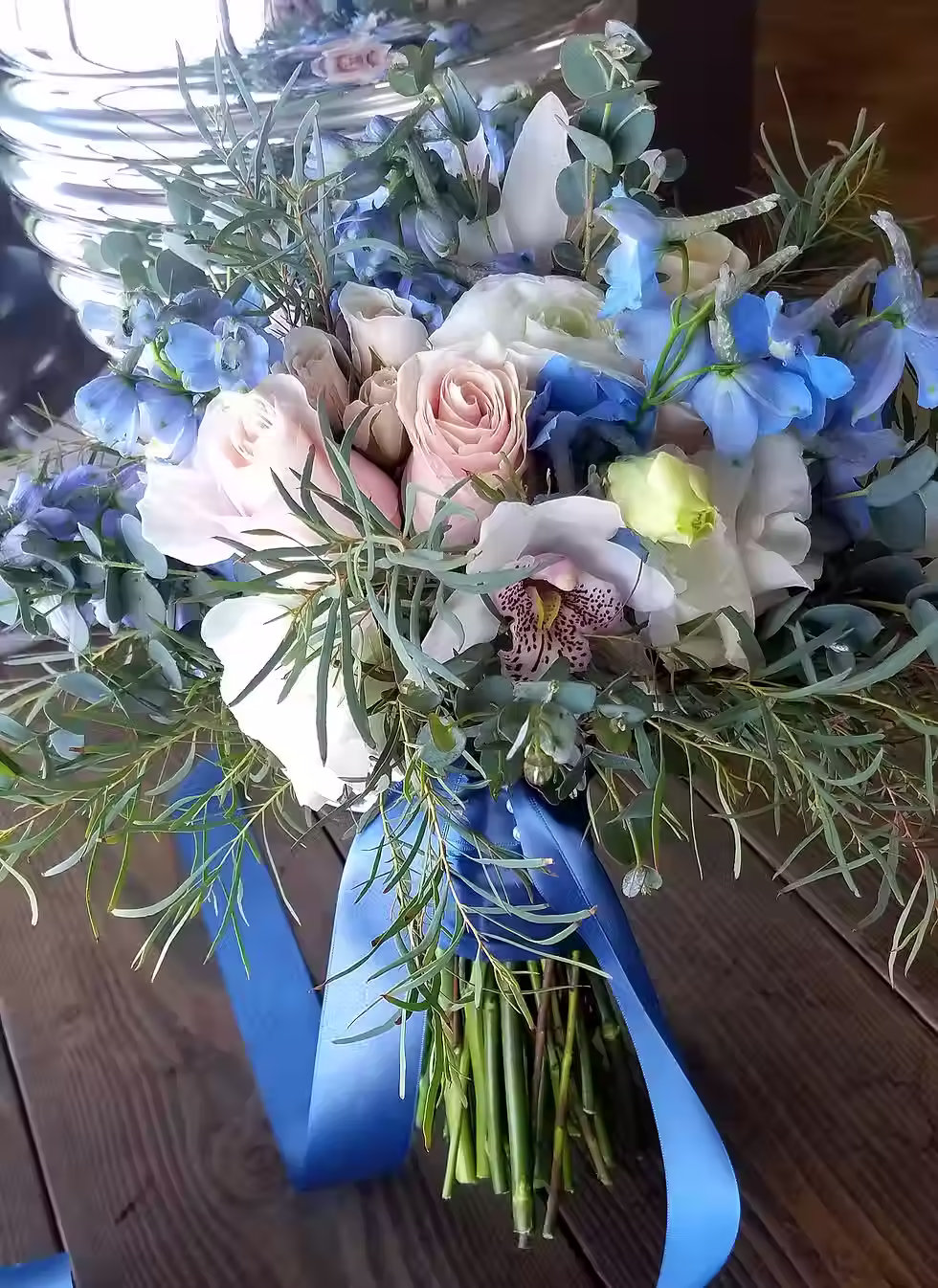 Price: $250.00
We used delphinium, cymbidium orchids, roses, ranunculus, lisianthus, willow eucalyptus, and gunni eucalyptus in this 