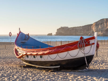 Traditional wooden boat on the sand at Nazare Beach Portugal