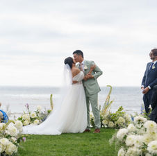 A couple shares a kiss at their wedding at Scripps Seaside Forum