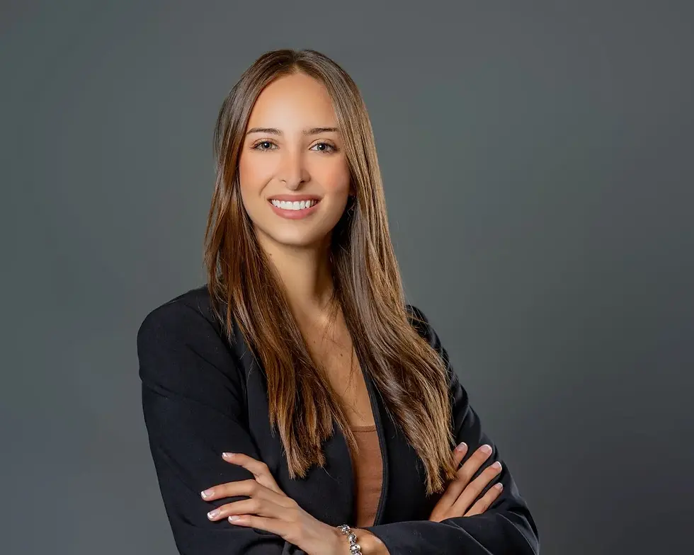 Austin professional headshot of a smiling woman in a black blazer on a grey backdrop
