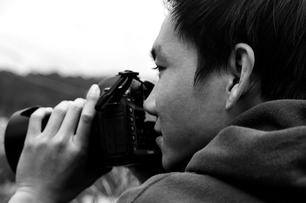 A professional photographer peering through a lense.