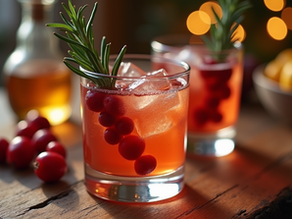 Eye-level view of a festive holiday cocktail with cranberries and rosemary garnish on a wooden table