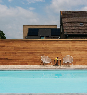 Zwembad met stoelen en houten wand