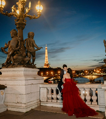 a couple kissing on couple popping champagne at pont de alexandre iii