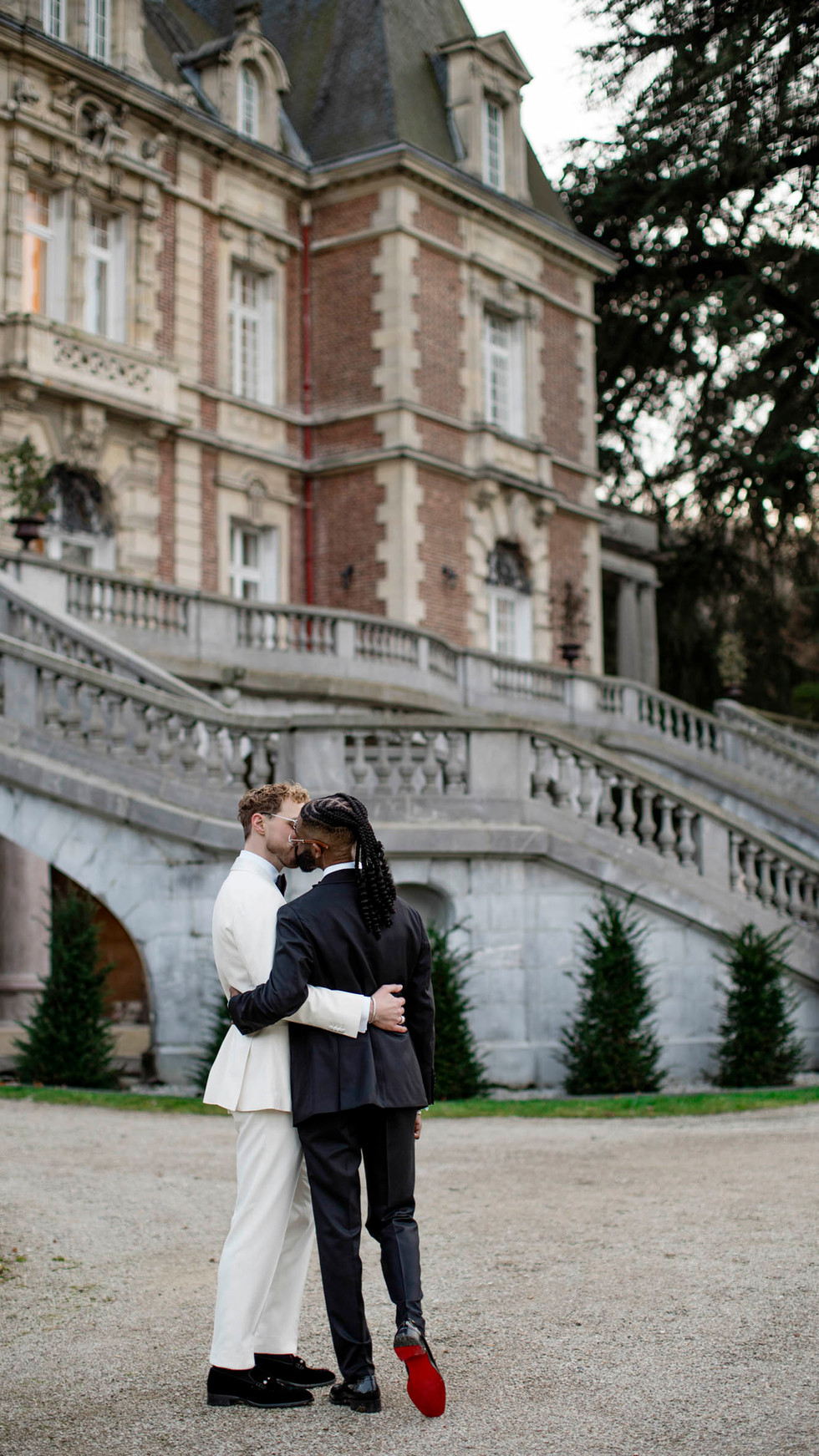 Couple on staircase with château architecture in the background