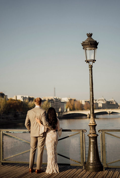 A romantic couple walking on Pont des Arts, a top Paris photoshoot location.