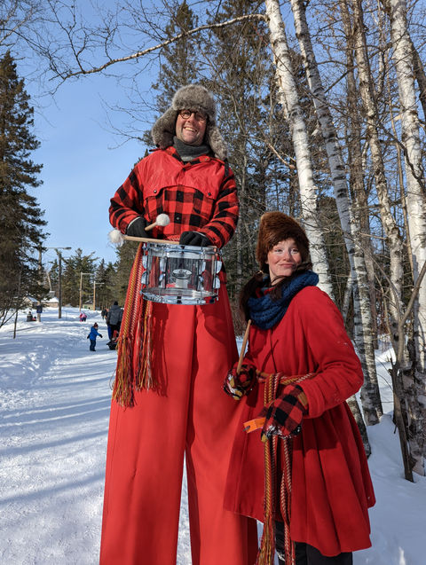 Personnages vêtes de rouge avec une ceinture a la taille dans un décor hivernal