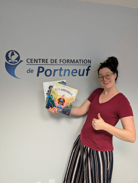 Femme tenant des livre de lecture devant le logo du centre de formation de portneuf