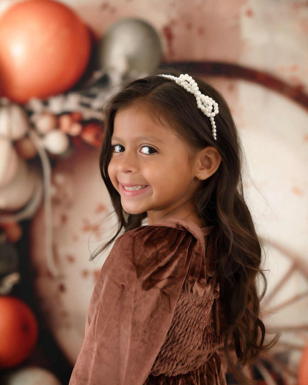 Rustic desert-themed cake smash backdrop with sage and terracotta balloons, wagon wheels, dried flowers, and cacti – perfect for first birthday photography