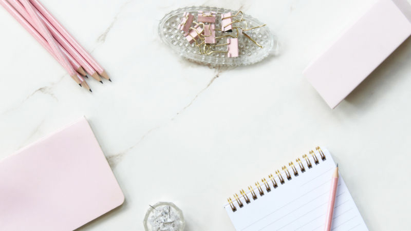 Minimal pink workspace with notebook and stationery symbolizing virtual assistant services and business organization