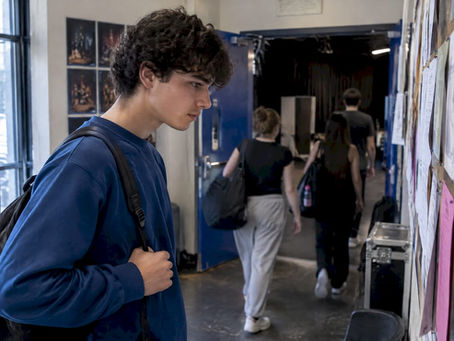 Young performer checking a theatre call board
