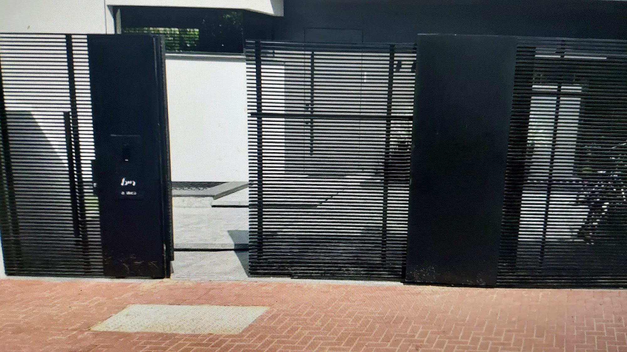 שער ומסך בכניסה לבית לצד קיר חיצוני