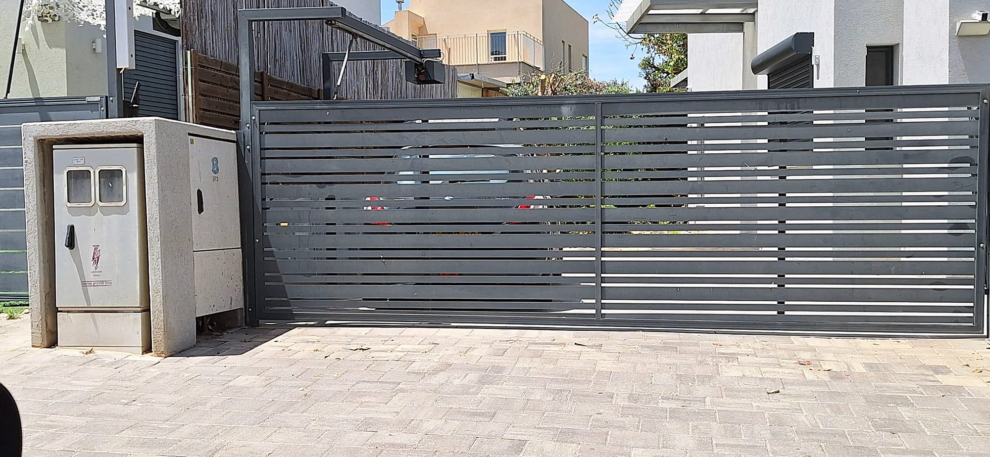 גדר מתכת עם פאנלים ושער בכניסה לחצר