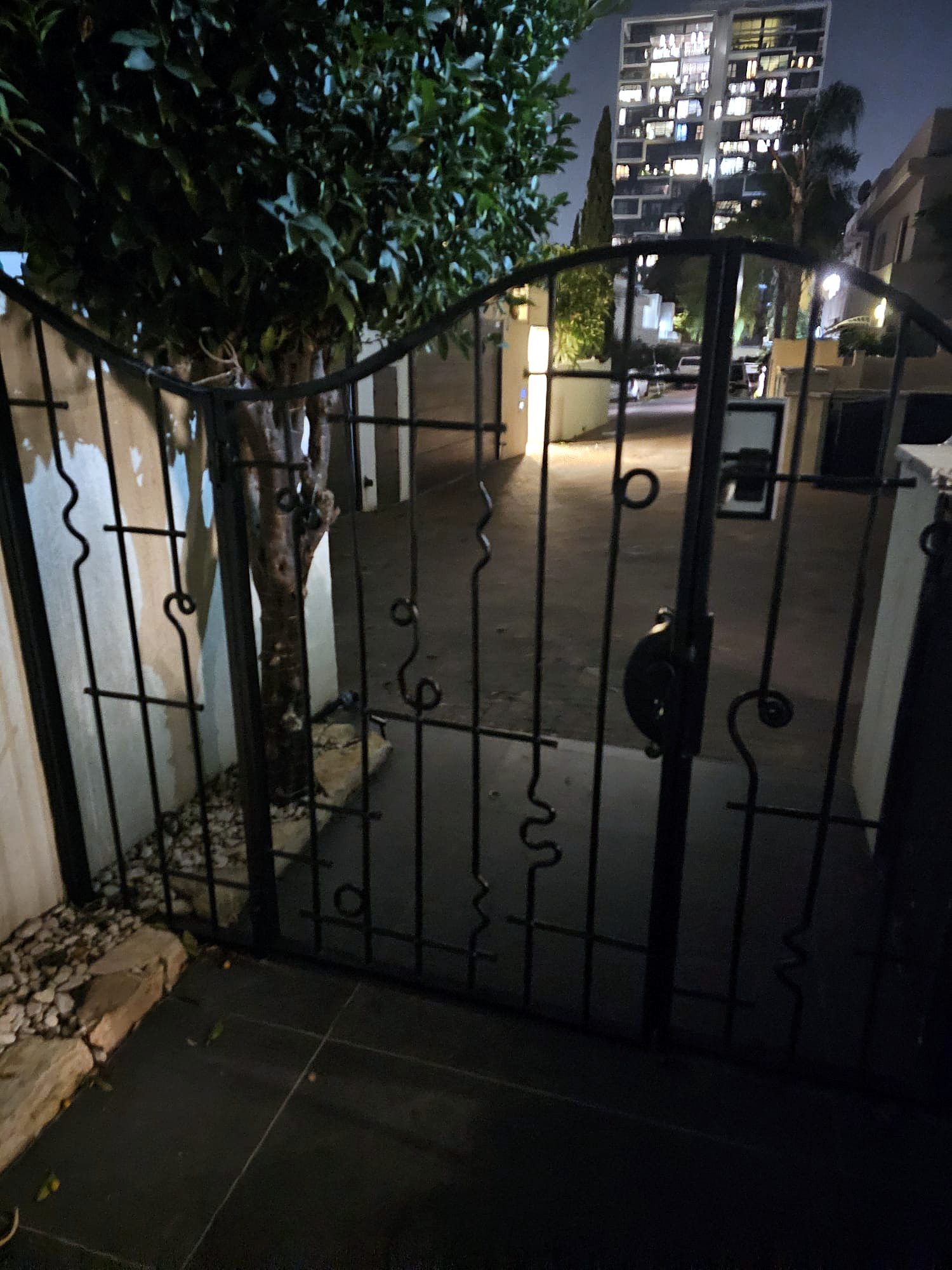 שער ברזל מעוצב בכניסה לבית בשעות הערב
