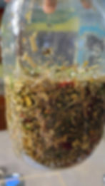 Jar of oils and herbs that are combine together to make the Stiff & Achey Oil