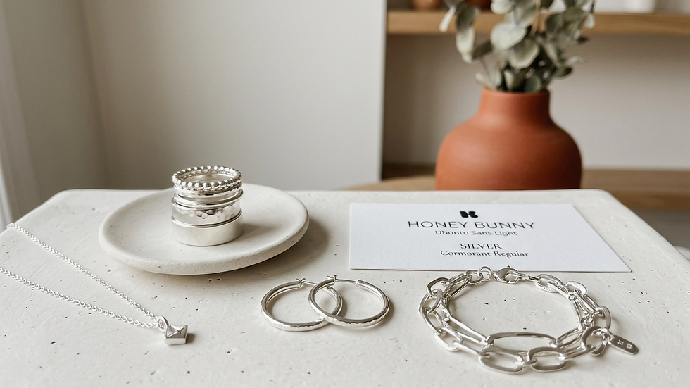Eye-level view of silver jewelry displayed on a minimalist white surface