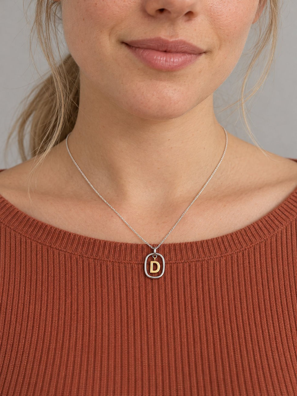 Modelo usando collar Love Letters letra D con marco redondeado y cadena barbada delgada.