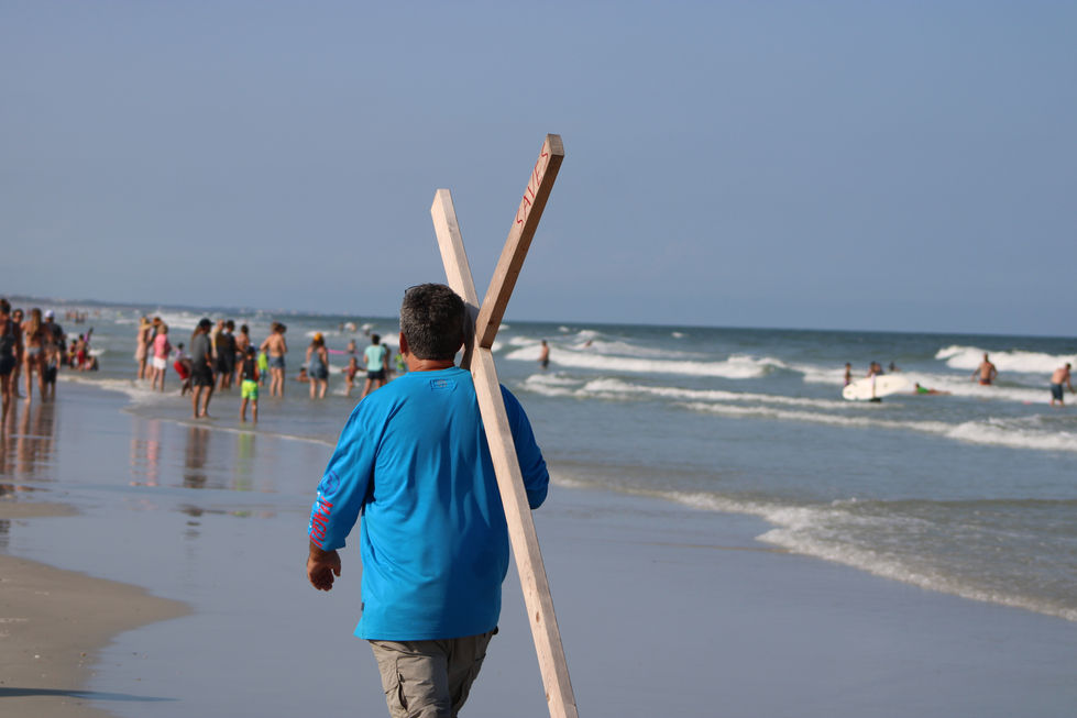 Person carrying surfboards on JAX Beach