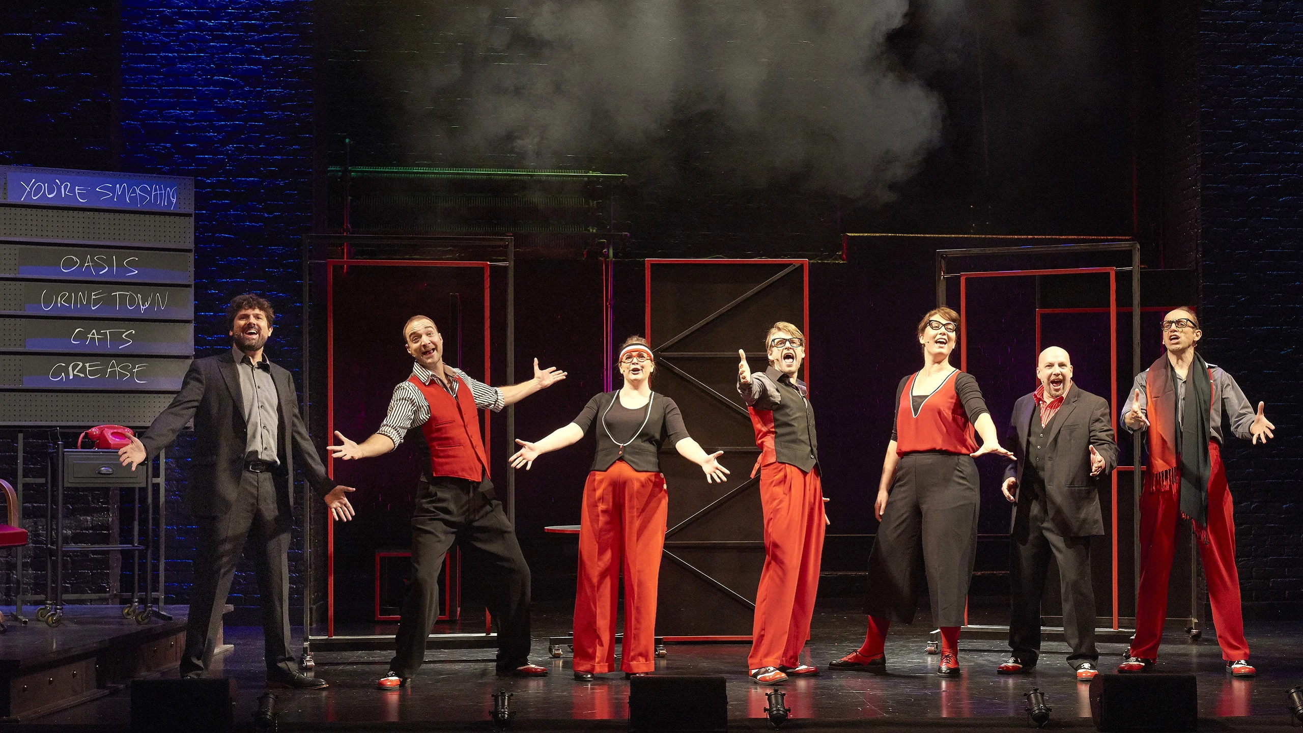 The cast of showstopper stand in a line singing