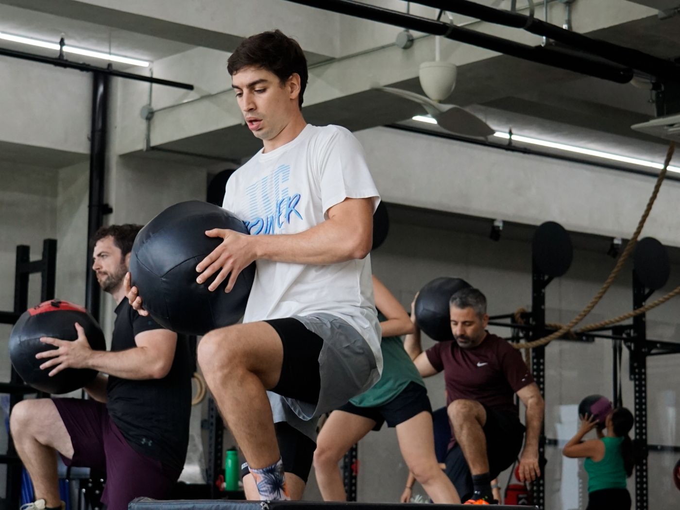 Members doing med ball step-ups together in a coached FAST session