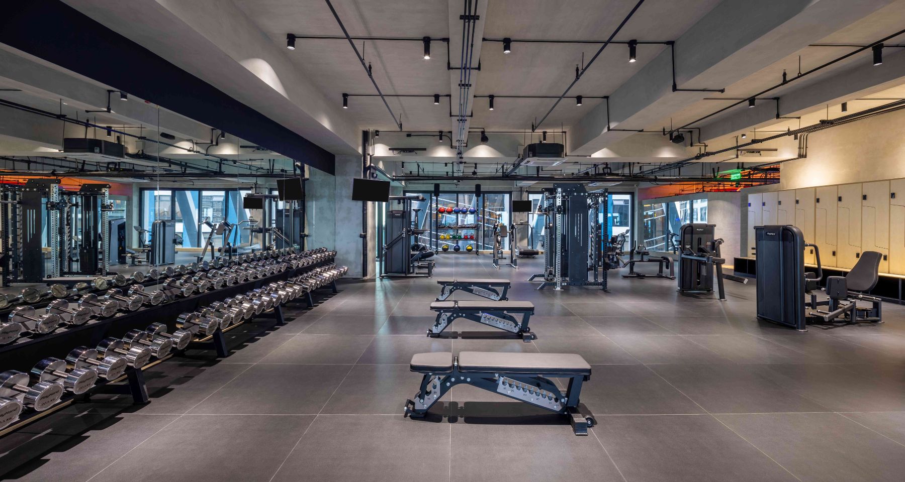 Dumbbell racks and benches on the 8th-floor gym