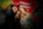 An empowering, alternative boudoir image of a blonde female posing on a graffiti background