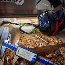 Werkzeuge und Arbeitschutzmittel mit Holzspänen auf einer CNC-Fräse