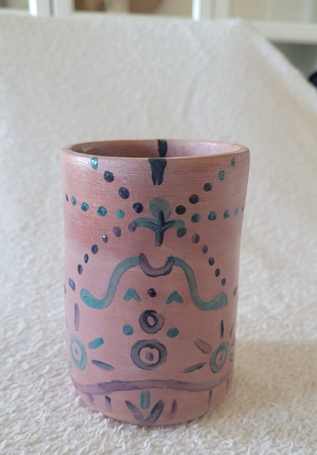 Vaso de cerámica artesanal sobre una toalla blanca, fotografía base utilizada para demostrar la aplicación de herramientas de IA para emprendedoras en la edición de imágenes.