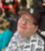 Man smiles, wearing glasses and Chicago White Sox shirt and hat near R logo.