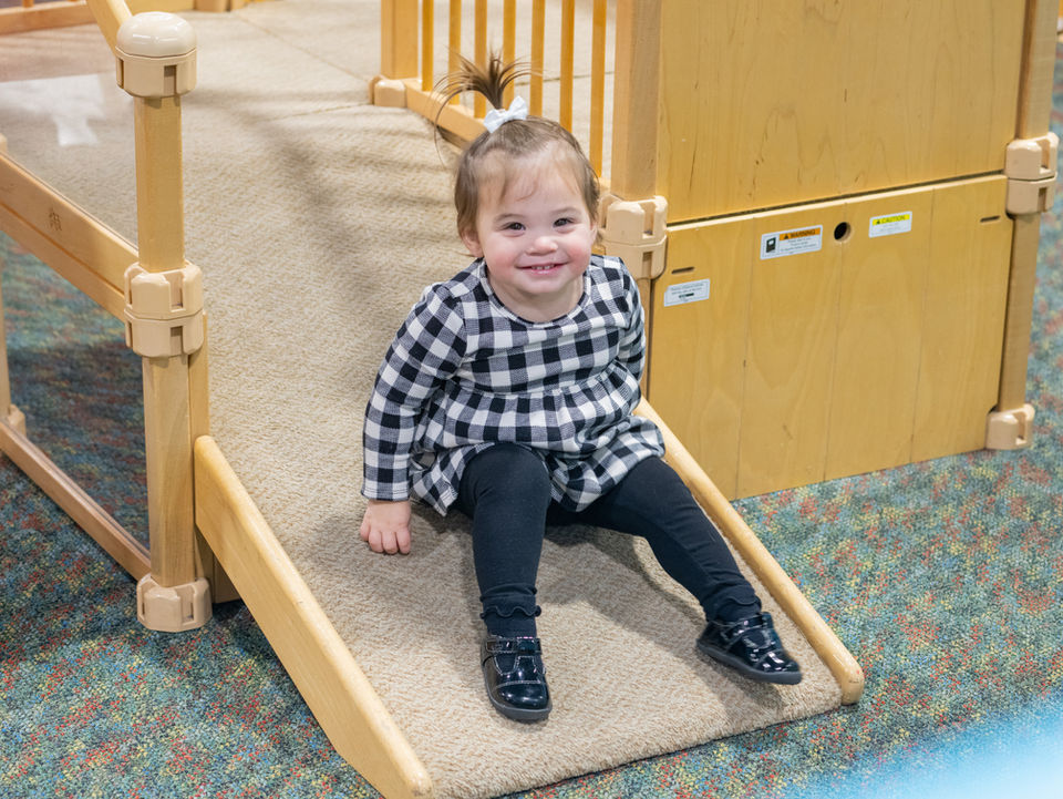 tummy time exhibit for little children girl going down slide