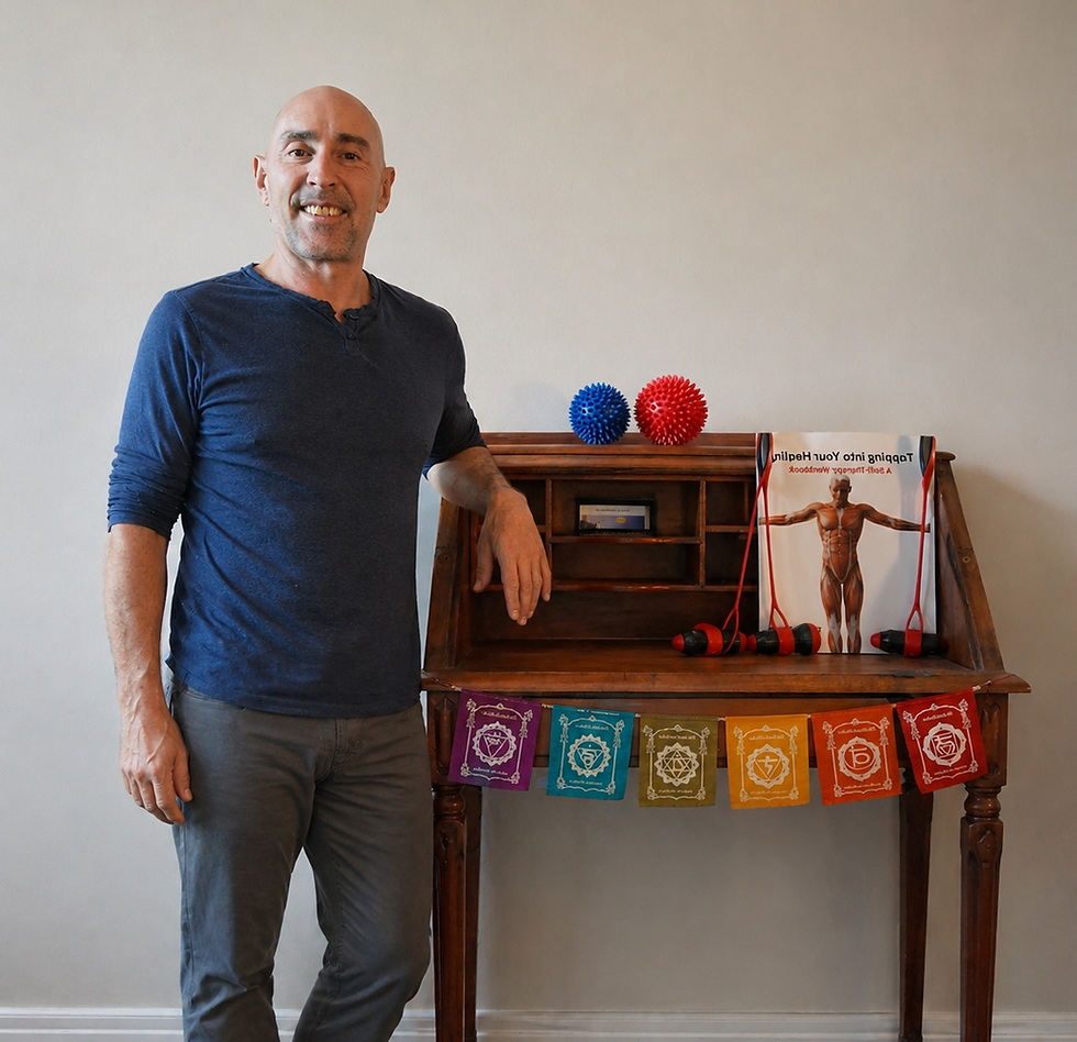 Barefoot man leaning on desk with chakra flags