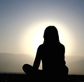 Woman with her back turned looking into the sun, symbolizing reflection and life transition, representing women in perimenopause seeking therapy in Illinois for emotional support, identity shifts, and hormonal transitions.